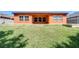 Backyard featuring an open patio, large windows, and an expansive grassy area, ideal for outdoor activities at 4289 Ortona Ln, Wesley Chapel, FL 33543