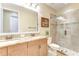 Bathroom with a granite double vanity, glass shower, tile surround, and neutral paint at 4289 Ortona Ln, Wesley Chapel, FL 33543