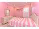 Bright bedroom with pink walls, white trim, a striped pink and white bed cover, and a window with shutters at 4289 Ortona Ln, Wesley Chapel, FL 33543