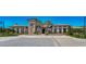 Stately clubhouse featuring stone accents, arched windows, tiled roof, and inviting entrance with manicured landscaping at 4289 Ortona Ln, Wesley Chapel, FL 33543