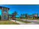 Elegant community entrance with stone gatehouse, manicured lawns, palm trees, and professional landscaping at 4289 Ortona Ln, Wesley Chapel, FL 33543