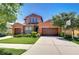 Charming two-story home with a three-car garage, colorful stucco, manicured lawn, and stone accents at 4289 Ortona Ln, Wesley Chapel, FL 33543