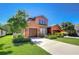 Charming two-story home with a three-car garage, colorful stucco, manicured lawn, and stone accents at 4289 Ortona Ln, Wesley Chapel, FL 33543