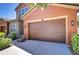 Close-up of the home's three-car garage, with wood doors, and lantern lighting, adding curb appeal at 4289 Ortona Ln, Wesley Chapel, FL 33543