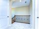 Hallway with a wooden staircase, white trim, and neutral paint at 4289 Ortona Ln, Wesley Chapel, FL 33543