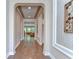 Hallway with hardwood floors, archways, neutral walls, and framed wall art at 4289 Ortona Ln, Wesley Chapel, FL 33543