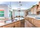 Modern kitchen boasts wood floors and cabinets, expansive counter space, and seamless flow into the dining area at 4289 Ortona Ln, Wesley Chapel, FL 33543