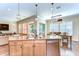The kitchen's center island and adjacent dining area make it perfect for entertaining, bathed in natural light at 4289 Ortona Ln, Wesley Chapel, FL 33543