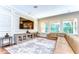 Living room with hardwood floors, media console, large windows, and sectional sofa at 4289 Ortona Ln, Wesley Chapel, FL 33543