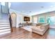 Spacious living room with hardwood floors, a large sectional sofa, and stairway at 4289 Ortona Ln, Wesley Chapel, FL 33543