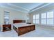 Serene main bedroom featuring tray ceilings, elegant decor, and bright windows creating a relaxing retreat at 4289 Ortona Ln, Wesley Chapel, FL 33543
