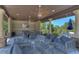 Inviting outdoor kitchen and lounge area with ceiling fans, comfortable seating, and a television at 4289 Ortona Ln, Wesley Chapel, FL 33543