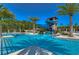 Resort-style pool with water slide, palm trees, and lounge chairs under a clear blue sky at 4289 Ortona Ln, Wesley Chapel, FL 33543