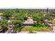 Aerial view of a charming home surrounded by mature trees, showcasing its well-manicured lawn and inviting curb appeal at 4340 Narvarez S Way, St Petersburg, FL 33712