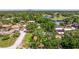 Aerial view of a neighborhood with mature trees, a lake, and a golf course in the distance, showcasing community amenities at 4340 Narvarez S Way, St Petersburg, FL 33712