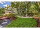 Lush backyard with fire pit, tropical landscaping, and stone pathway, creating a serene outdoor oasis at 4340 Narvarez S Way, St Petersburg, FL 33712