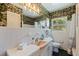 Charming bathroom with floral wallpaper, white tile, and a window offering natural light and view at 4340 Narvarez S Way, St Petersburg, FL 33712
