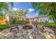 Paver patio with fire pit provides a relaxing backyard retreat, surrounded by lush landscaping and green grass at 4340 Narvarez S Way, St Petersburg, FL 33712