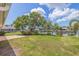 Spacious yard with a large tree, dock access to the canal, and views of the screened-in pool area at 4433 38Th S Way, St Petersburg, FL 33711
