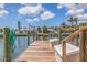 Waterfront dock featuring wood planks and green posts with a calm canal and clear skies at 4433 38Th S Way, St Petersburg, FL 33711