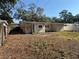 Backyard of a home with a mix of grassy areas and patches of leaves at 4716 W Vasconia St, Tampa, FL 33629