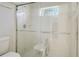 Bright bathroom featuring a walk-in shower with safety bars, a small window, and white tiling at 4909 Linsey Ct # 0, Sarasota, FL 34243