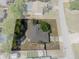 Aerial view showcasing the property's backyard, mature trees, fenced perimeter, and roofline at 5263 Kirkwood Ave, Spring Hill, FL 34608
