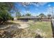 View of back of house featuring screened porch and a fenced yard with mature trees at 5263 Kirkwood Ave, Spring Hill, FL 34608