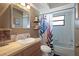 Cozy bathroom featuring a wooden vanity, decorative shelving, and stylish shower curtain at 5263 Kirkwood Ave, Spring Hill, FL 34608