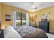 Bright bedroom with a large window and light yellow walls features a ceiling fan and tasteful decor at 5263 Kirkwood Ave, Spring Hill, FL 34608