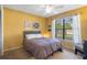 Bright bedroom featuring yellow walls, natural light, and a bed with white linens at 5263 Kirkwood Ave, Spring Hill, FL 34608