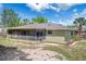 Back of the house featuring a large screened in porch and manicured landscaping at 5263 Kirkwood Ave, Spring Hill, FL 34608