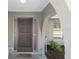 Welcoming front porch with an arched entryway, textured sidelights, and view to the yard at 5263 Kirkwood Ave, Spring Hill, FL 34608