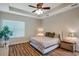 Comfortable bedroom with tray ceiling, wood floors, and natural light at 5518 72Nd E Ter, Ellenton, FL 34222