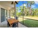 Outdoor patio showcasing a dining table, overlooking a lush backyard with mature trees and landscaping at 5518 72Nd E Ter, Ellenton, FL 34222