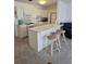 Well-lit kitchen with white cabinetry and three barstools at 5623 80Th N St # 306, St Petersburg, FL 33709