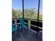 Relaxing screened balcony with serene treetop views, comfortable seating, and a tiled floor at 6080 80Th N St # 409, St Petersburg, FL 33709