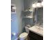 Bright bathroom featuring a sink, a toilet, and decorative wall shelves at 6080 80Th N St # 409, St Petersburg, FL 33709