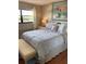 Bedroom with a window and a bed with blue patterned bedding and bench at 6080 80Th N St # 409, St Petersburg, FL 33709