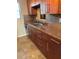 Kitchen showing stainless steel sink, tile backsplash, and brown cabinets at 6080 80Th N St # 409, St Petersburg, FL 33709