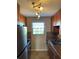Galley kitchen featuring stainless steel appliances, tile floors and back splash, and wood cabinets at 6080 80Th N St # 409, St Petersburg, FL 33709