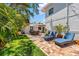 Spacious backyard area featuring lush green grass, blue lounge chairs, and brick patio at 6213 12Th S Ave, Gulfport, FL 33707