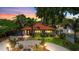 Sunset view of a charming home with a red tile roof, manicured lawn, and mature trees at 6213 12Th S Ave, Gulfport, FL 33707