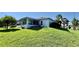 Exterior side view showing an enclosed porch, well-kept lawn and lush landscaping at 6446 Louisiana Ave, New Port Richey, FL 34653