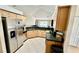 Well-lit kitchen with stainless steel refrigerator and wooden cabinets at 6446 Louisiana Ave, New Port Richey, FL 34653