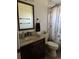 Bathroom features granite countertop vanity with dark wood cabinets and decorative shower curtain at 7033 123Rd St, Seminole, FL 33772