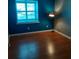 Cozy bedroom features hardwood floors, a bright window, and cool blue walls at 7033 123Rd St, Seminole, FL 33772