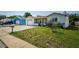 Well-maintained front yard with lush green grass, a lovely home exterior, and a clean driveway at 7420 Cay Dr, Port Richey, FL 34668