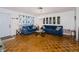 Bright living room featuring hardwood floors, comfortable blue couches, and decorative lighting at 7420 Cay Dr, Port Richey, FL 34668