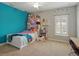 Charming bedroom featuring a bright blue wall, fun decorations, and ample natural light at 7927 Hampton Lake Dr, Tampa, FL 33647